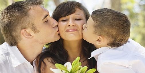 mother receiving kisses from her husband and son on mothers day